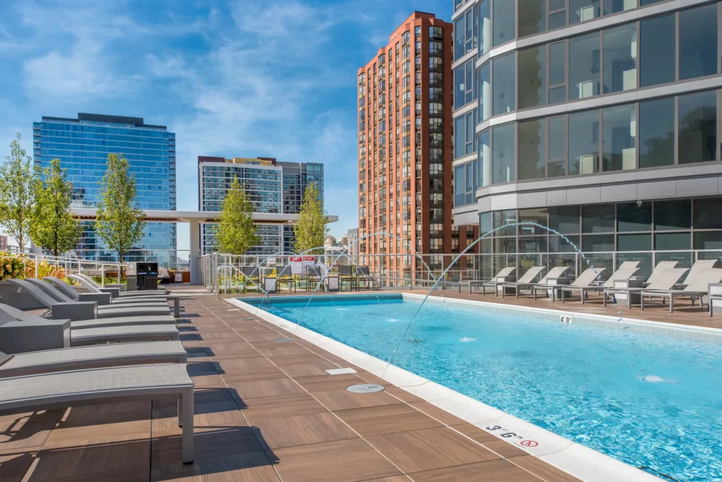 The rooftop pool at 1001 S State Apartments in Chicago, surrounded by blue sky and towering buildings.