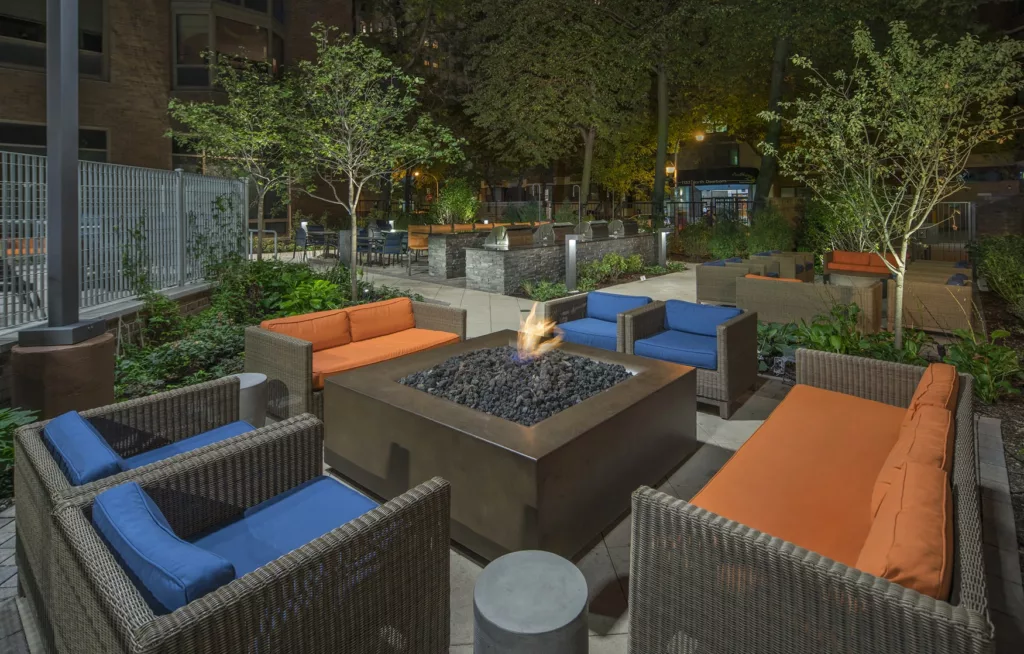 A cozy outdoor fire pit and lounge chairs at Elm Street Apartments in Chicago's Gold Coast 