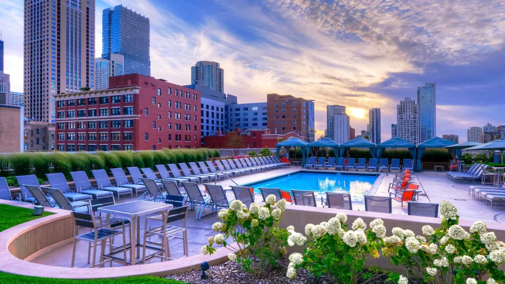 A view of Grand Plaza Apartments rooftop pool and lounge, surrounded by the downtown Chicago skyline