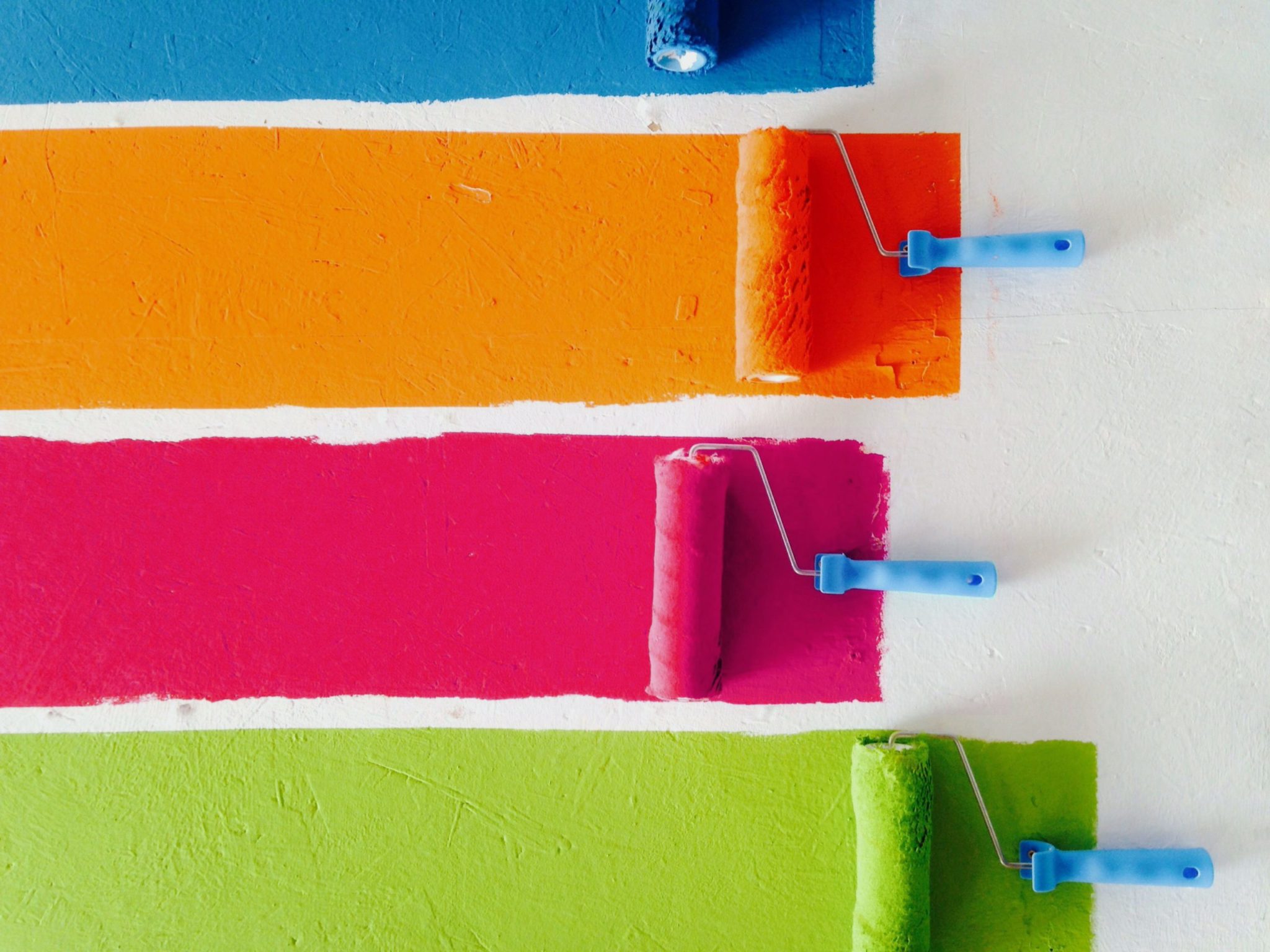 Colorful paints being painted on a wall