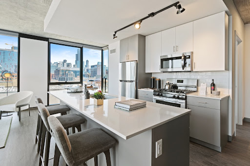 Bright white kitchen with a large island and stainless steel appliances.