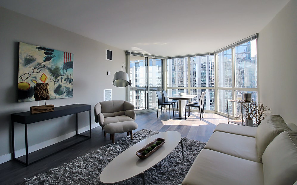 Spacious living area with sunny bay windows at Chicago's One East Delaware Apartments